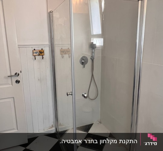 מקלחון פינתי מזכוכית שקופה שהותקן בחדר רחצה